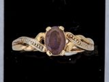 une photo d'une bague en or sertie d'une pierre violette