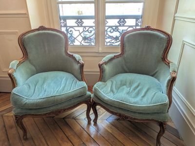 pair of blue upholstered chairs sitting in front of a window