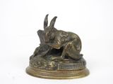 statue en bronze représentant un lapin sur un socle, sur fond blanc