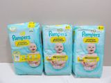 three packs of baby diapers sitting on top of a table