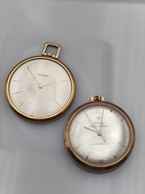 two gold pocket watches, one with a white dial and the other with a gold case