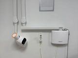 a bathroom with a toilet and a shower head mounted to the wall