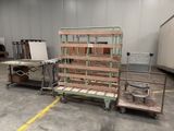 several pallets of wood sit in a warehouse with a cart in the foreground