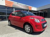 a red small car parked in front of a building