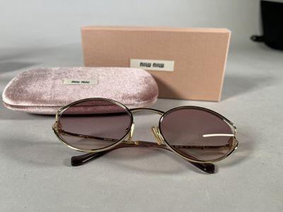 sunglasses in a case and a pair of glasses sitting on a table