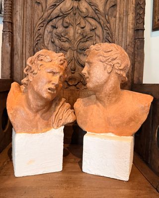 deux bustes d'hommes assis sur une chaise en bois