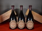 three bottles of wine are sitting on a table with a wooden box