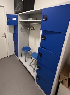 une armoire bleue et blanche dans une pièce où se trouve un tabouret bleu