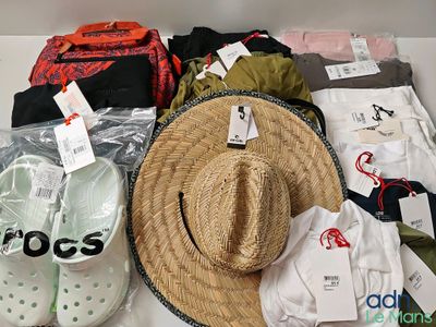 beaucoup de vêtements et un chapeau posés sur une table