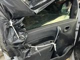 a car door covered with a tarp on the side of the road