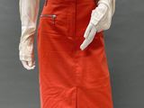 a mannequin wearing an orange skirt and white shirt