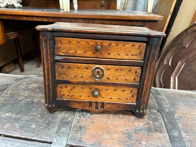 une petite commode en bois posée sur une table