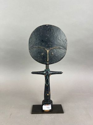 une image représentant une sculpture d'une femme tenant un grand disque