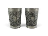 two cups that are sitting side by side on a white surface