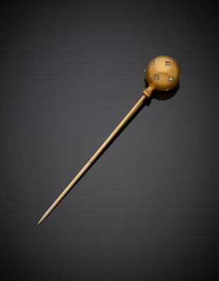 un bâton doré surmonté d'une boule, sur fond noir