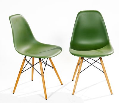 two green plastic chairs with wooden legs against a white background
