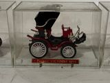 three small toy cars in a clear box