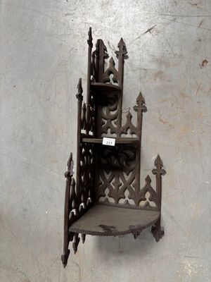 une étagère fixée au mur et sur laquelle est accrochée une pancarte