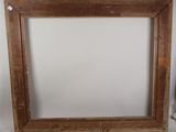 an old wooden picture frame sitting on top of a white wall