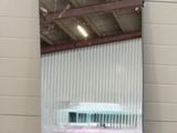a mirror on the wall of a building that has a reflection of a plane in it