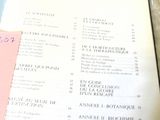 un livre ouvert sur lequel figure une liste, à côté d'une tasse de café