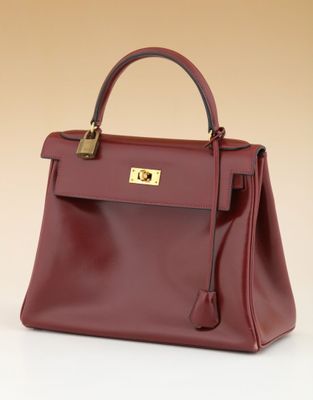a red leather handbag with a gold lock on the handle