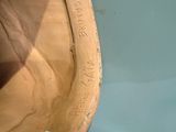 a close up of a wooden bowl with a sticker on it