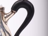 a silver teapot with a black handle on a white background