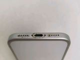 the back of a silver cell phone sitting on top of a white table