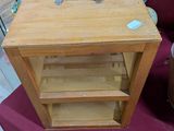 une petite table en bois sur laquelle est posée une valise
