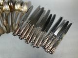 a lot of silver spoons and spoons on the table