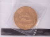 a gold coin in a plastic bag on a white surface