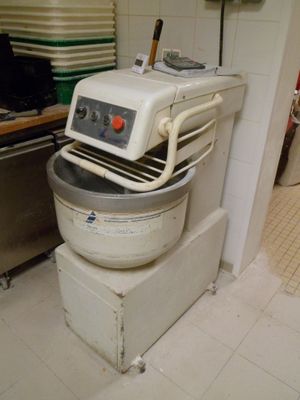 un grand robot blanc posé dans une cuisine, à côté d'une cuisinière