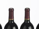 six bottles of wine are lined up in a row on a table