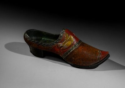 an old wooden clogger with a red and yellow design on the side