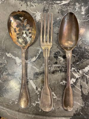 trois cuillères en argent et deux cuillères en argent sur une table