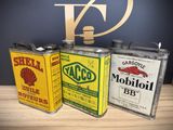 three cans of oil are sitting on a table next to a sign