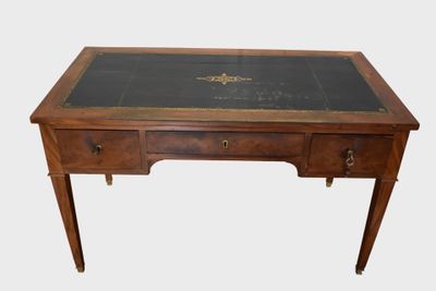 un bureau ancien avec un plateau en verre et des ferrures en laiton