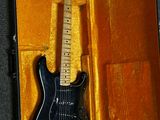 a black electric guitar in a case on the floor