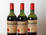trois bouteilles de vin posées sur une table en bois, sur fond blanc