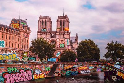 un bateau qui descend la rivière et qui est entièrement recouvert de graffitis