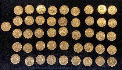 des pièces d'or sont disposées dans une vitrine posée sur un socle noir