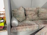 a couch and ottoman in a room with a window