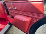 un gros plan sur la portière d'une voiture rouge avec un siège rouge