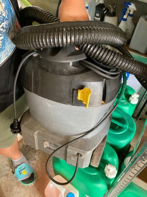a man standing next to a machine with a hose attached to it