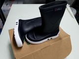 a pair of black rain boots on top of a cardboard box