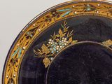 a black plate with gold and blue designs on it