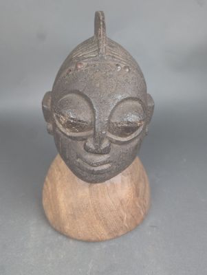 une petite statue représentant un homme, posée sur un socle en bois