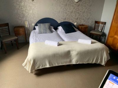 deux lits dans une chambre, avec un ordinateur portable posé par terre