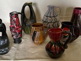 de nombreux vases de différentes couleurs posés sur une table